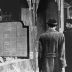 Ciudadanos alemanes al día siguiente de la noche de los cristales rotos, frente a tiendas y casas judías destruidas (National Archives and Records Administration, College Park)