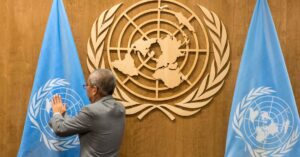 Un hombre coloca una bandera de la Organización de las Naciones Unidas