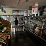 Un pasillo del supermercado a oscuras con un cliente intentando comprar